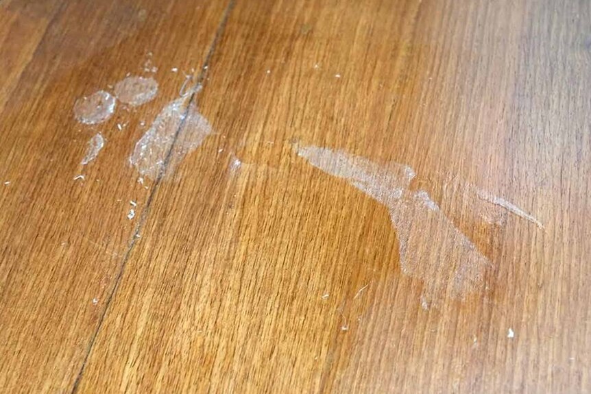 A foot print left on timber floorboards when a fisherman spilled superglue without realising and stuck himself in position.