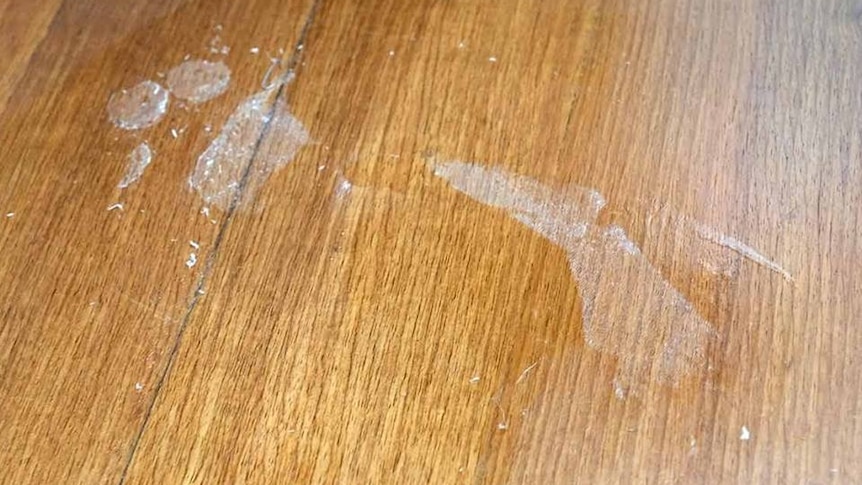 A foot print left on timber floorboards when a fisherman spilled superglue without realising and stuck himself in position.