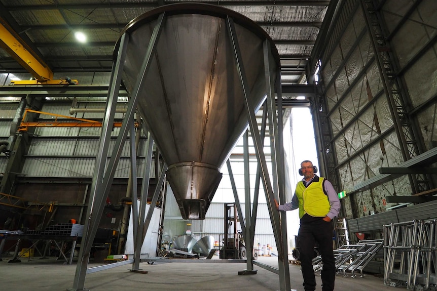 A man standing next to a big wheat solo