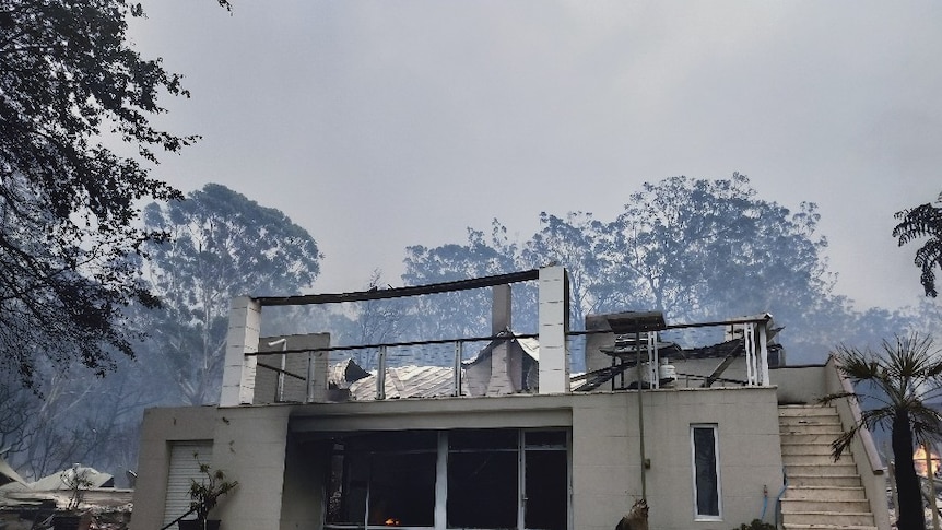 The remains of a white stone house after being burnt by a bushfire.