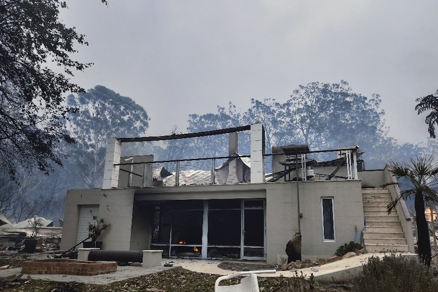 The remains of a white stone house after being burnt by a bushfire.