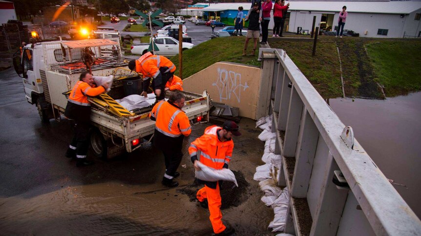 Council workers lay sand bags against floodgates in Launceston