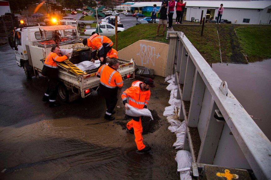Council workers lay sand bags against floodgates in Launceston