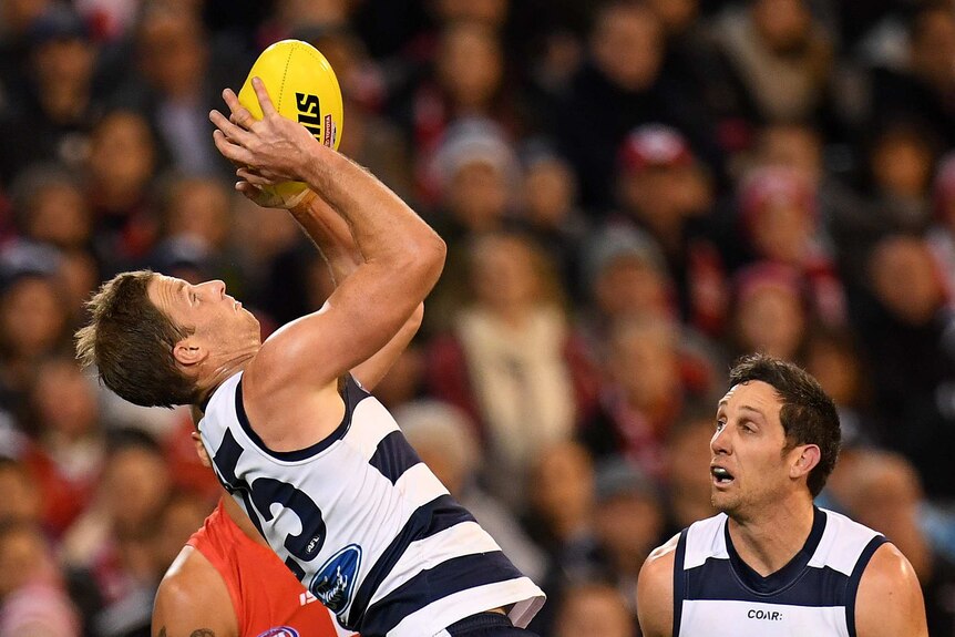 Lachie Henderson of the Cats (left) is seen in action against Sydney at the MCG.