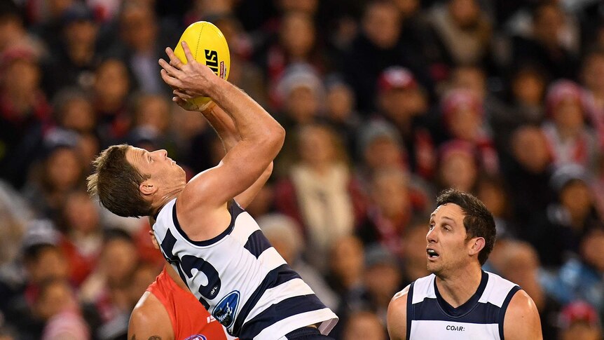 Lachie Henderson of the Cats (left) is seen in action against Sydney at the MCG.