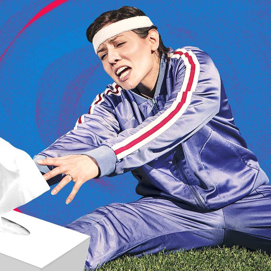 A woman in exercise tracksuit reaches for a box of tissues raising the question whether she should be exercising with a cold?