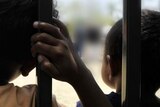 A close-up of the backs of the heads of two Aboriginal children.