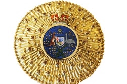 A gold badge is seen with a blue circle in the middle featuring an emu and a kangaroo, with a red crown on top.