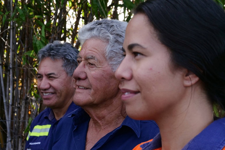 side profile shot of a father, grandfather, and daughter standing side by side