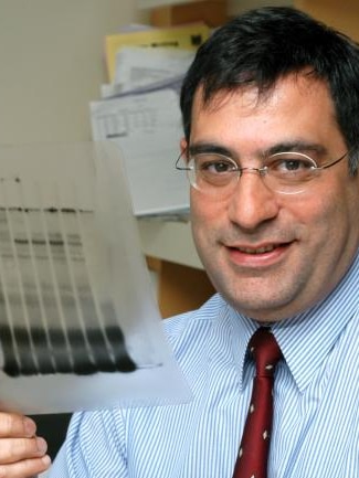 Man holding plastic sheet, wearing glasses shirt and red tie