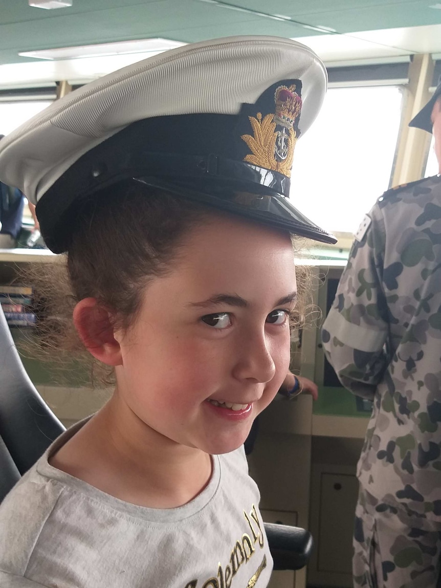 Girl wearing captain's hat in ship chair
