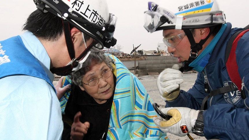 Sumi Abe is taken from the debris of her house in Ishimaki. (AFP: Kahoku Shimpo)