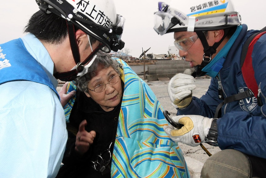Sumi Abe is taken from the debris of her house in Ishimaki. (AFP: Kahoku Shimpo)
