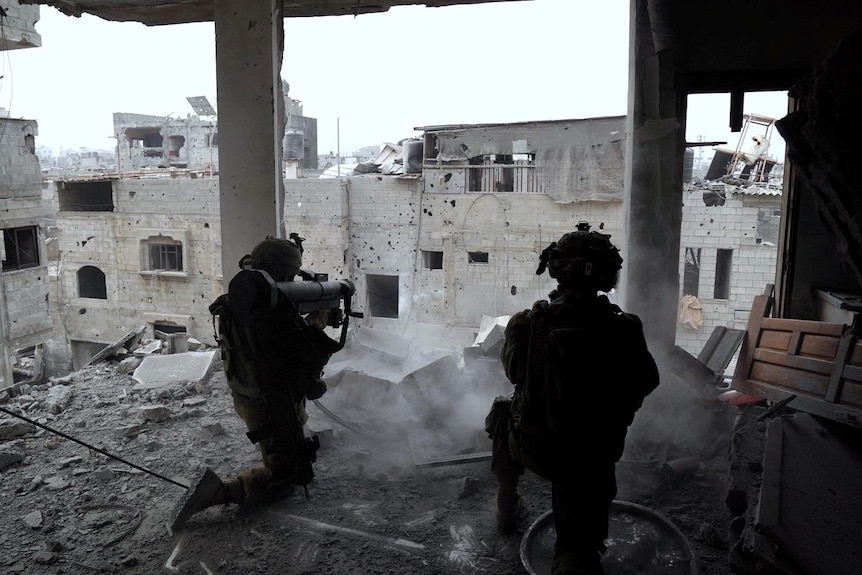 Two soldiers aim their weapons in a ruined building