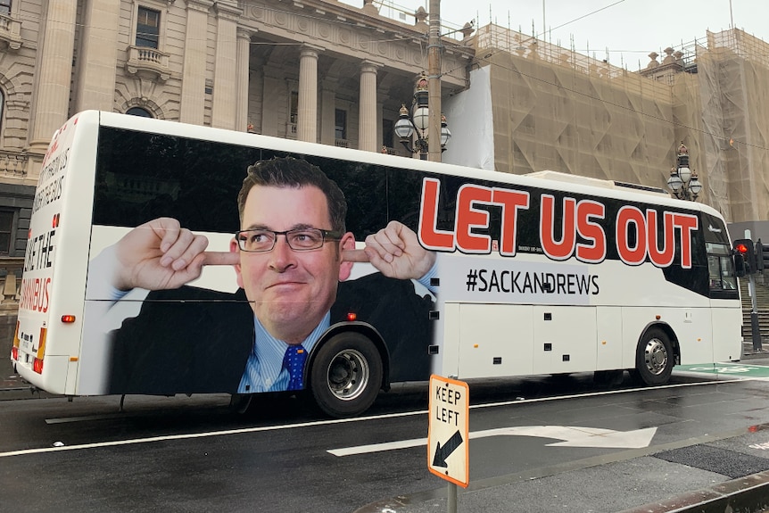 A bus adorned with the words 'let us out' and a picture of Daniel Andrews blocking his ears.
