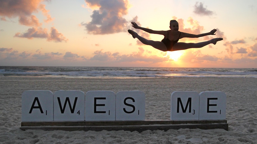 A girl leaps from giant scrabble pieces at Swell Sculpture Festival