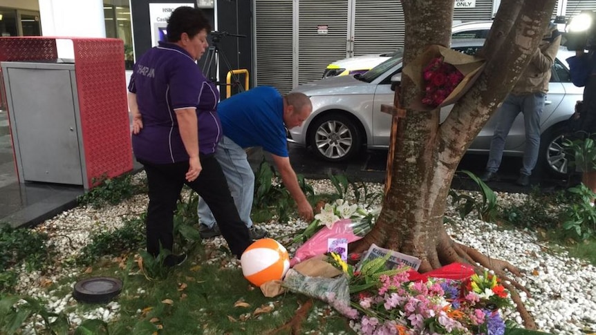 Mourners lay flowers at a vigil.