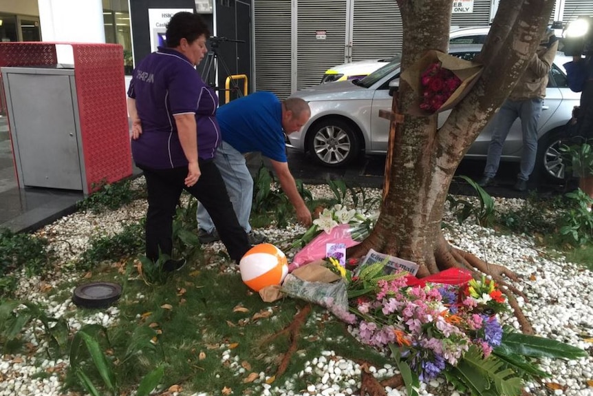 Mourners lay flowers at a vigil.