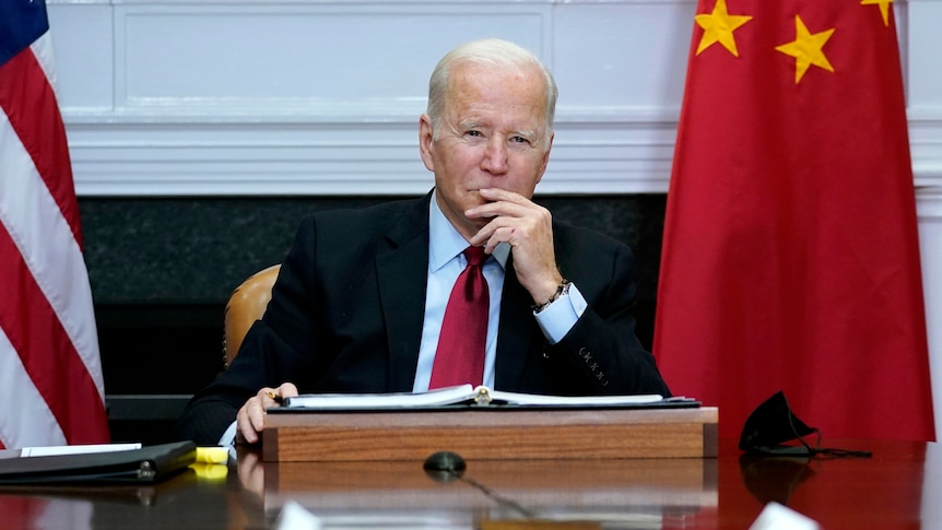 Joe Biden sits with his hand to lips.