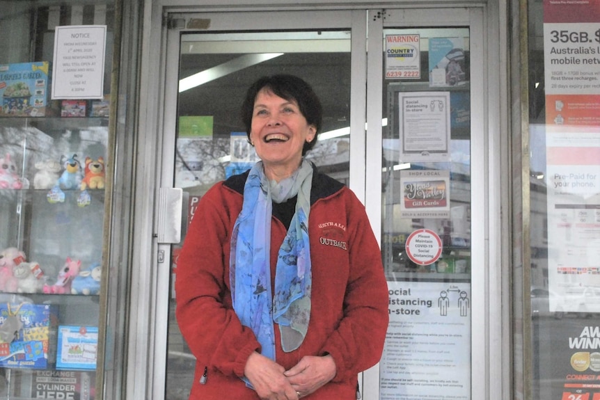 Business owner stands at door to retail outlet.