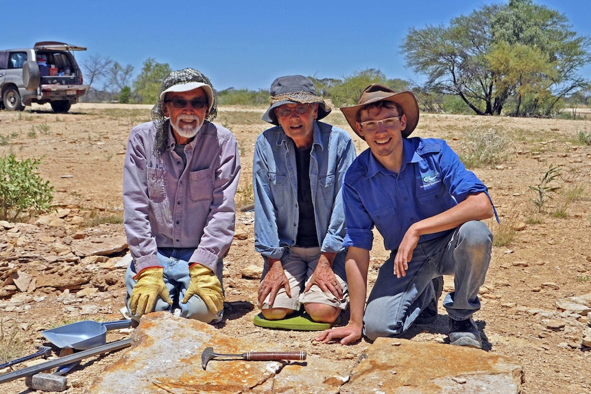 Dr Patrick Smith and volunteers Gary and Barbara Flewelling kneel over sight where rare lizardfish fossil was discovered.