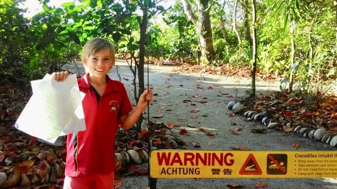 Boy holds up letter to Queensland Environment Minister Leanne Enoch