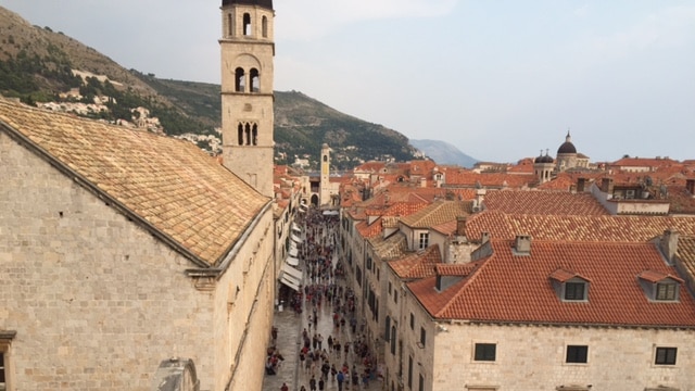 Tourists in Dubrovnik in Croatia walk down a street among old buildings