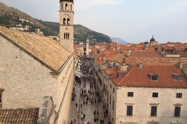 Tourists in Dubrovnik in Croatia walk down a street among old buildings