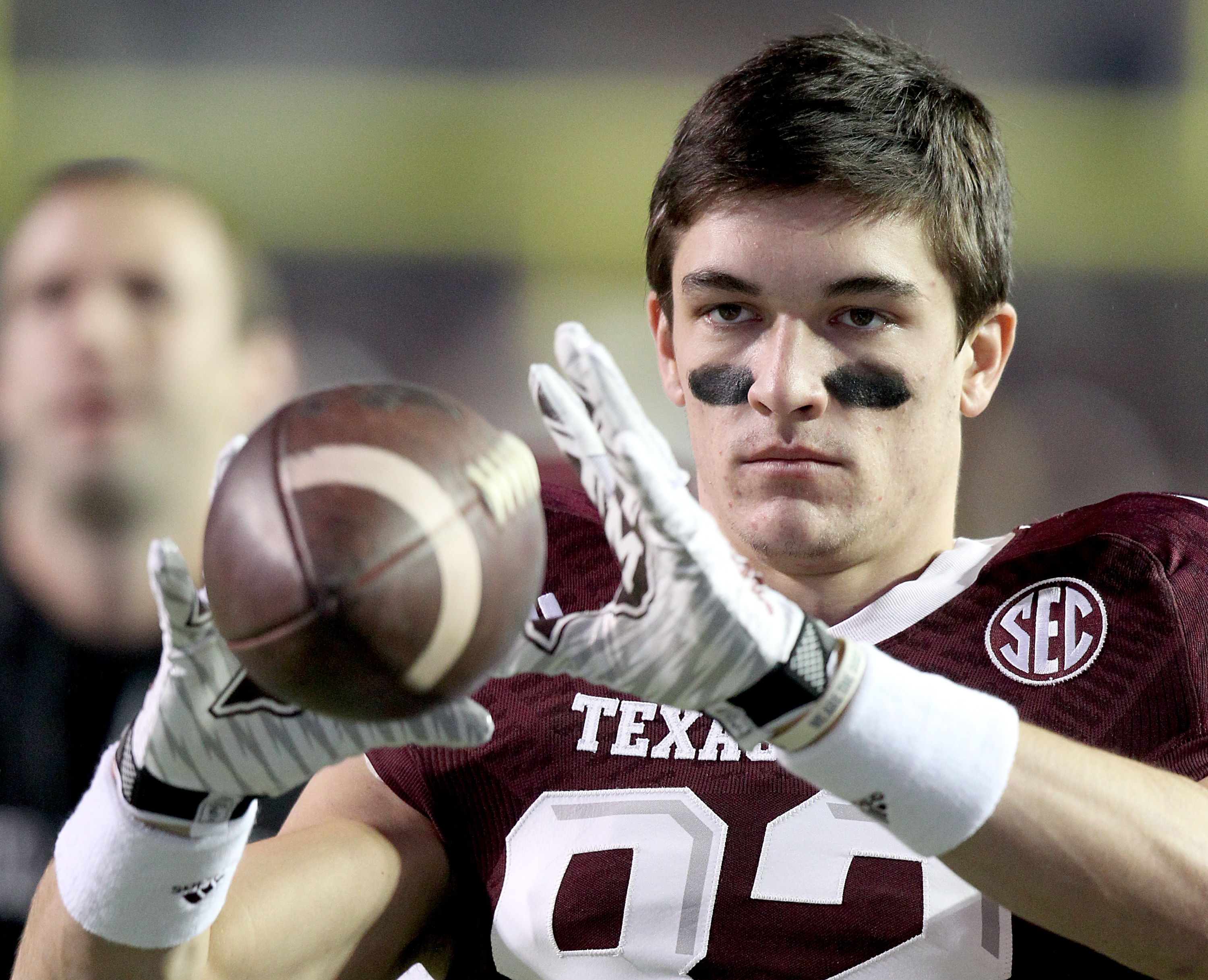 Boone Niederhofer atrapa una pelota de fútbol antes de un partido de Texas A&M.