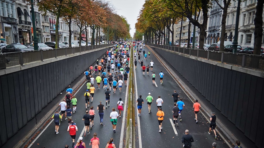 A large group of people running up a city street