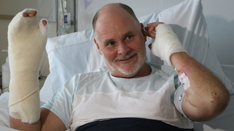 A man in hospital with both hands bandaged 