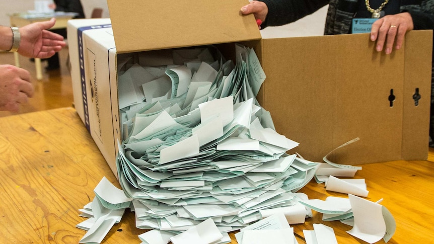 Green ballot papers are tipped out of ballot box.