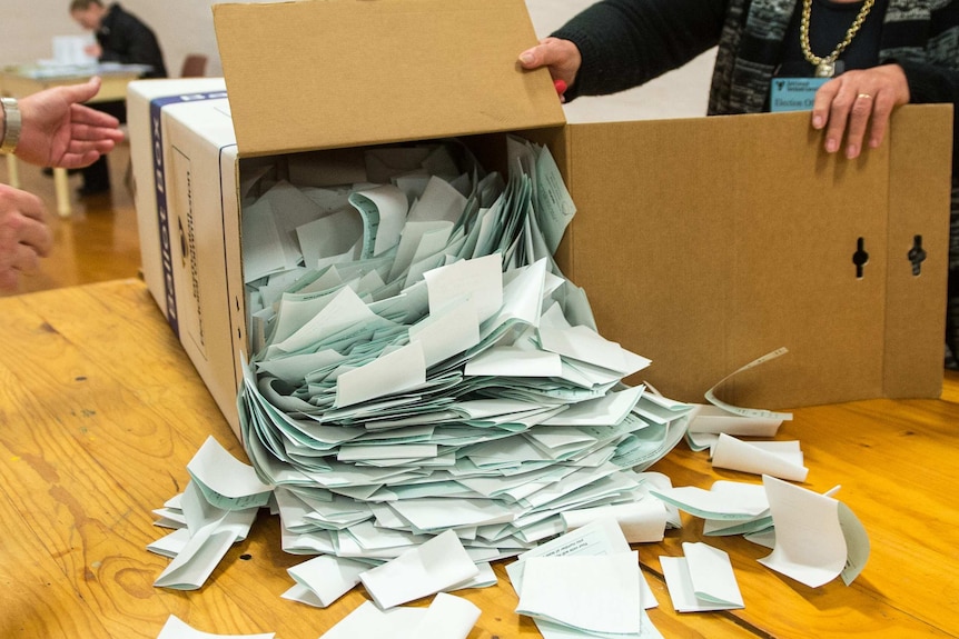 Green ballot papers are tipped out of ballot box.