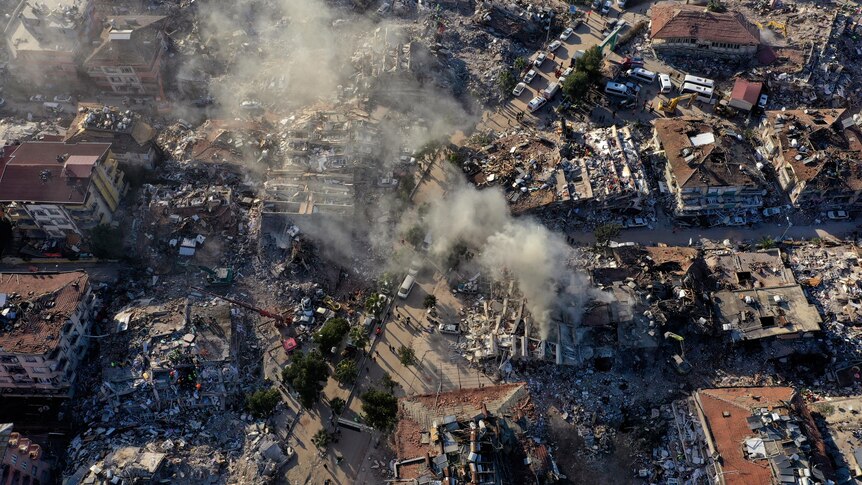 Destroyed buildings and dust seen rising from aerial view of city of Antakya, Turkiye.
