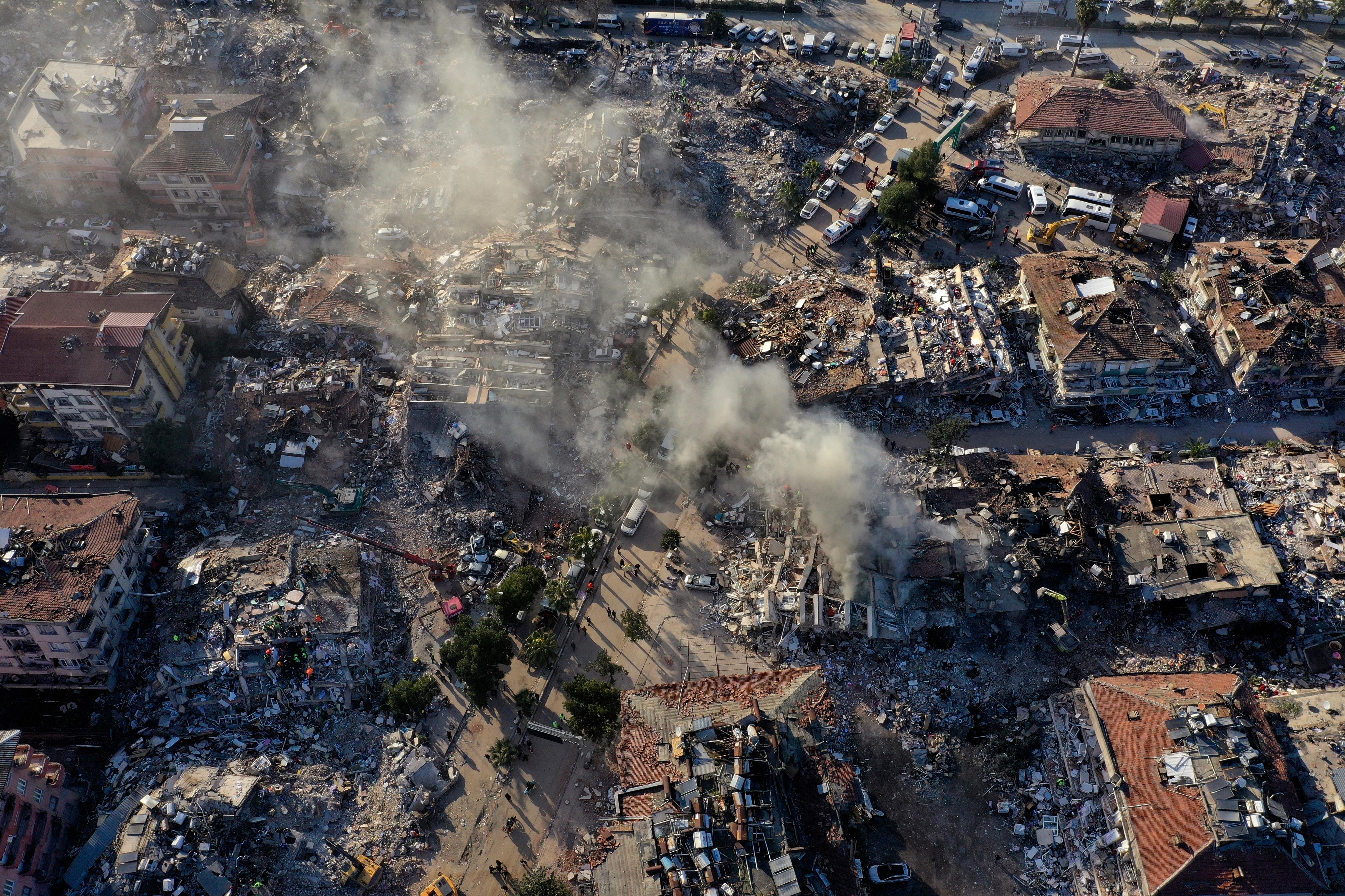 被毁的建筑物和从空中升起的灰尘土耳其安塔基亚市的景色。” class=