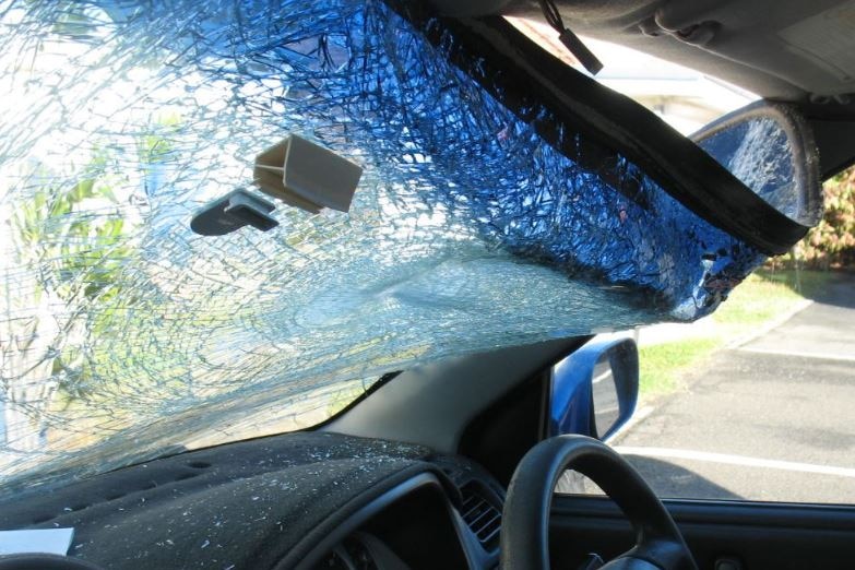 A windscreen which has been damaged after a large rock was thrown at it