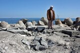 A Libyan man stands on Sirte's bombed fishing harbour.