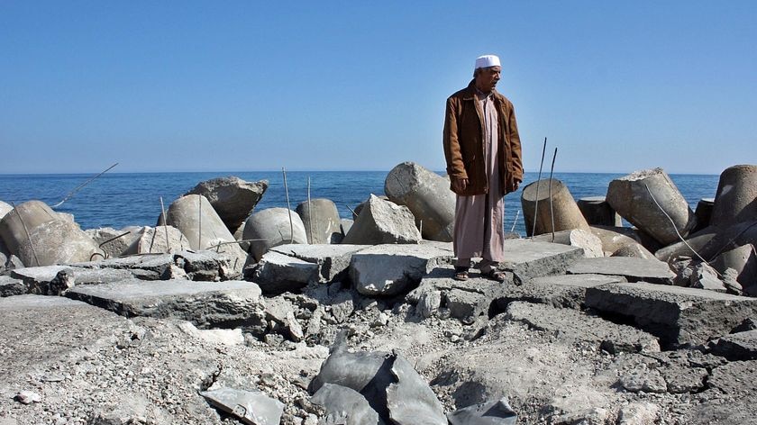A Libyan man stands on Sirte's bombed fishing harbour.