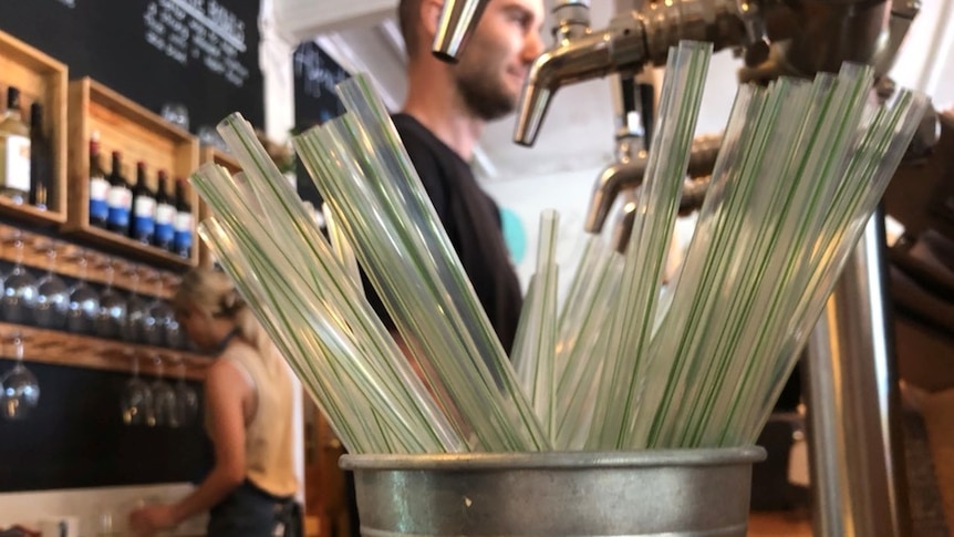 Clear straws in a metal bucket at a cafe