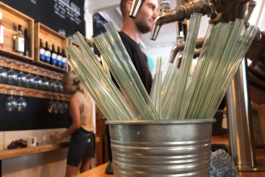 Clear straws in a metal bucket at a cafe