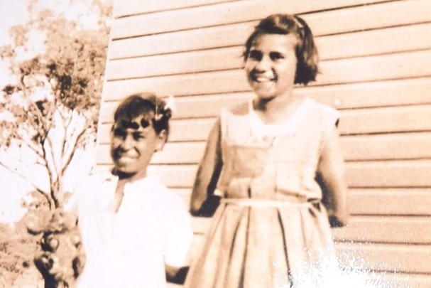 two young girls standing next to each other and smiling