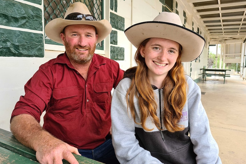 Grazier Wayne Smith and his daughter Jemma smiling sitting outside the Pooncarie Hotel.