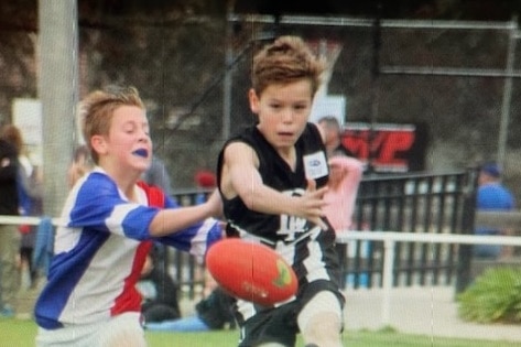 A young Aaron Cadman playing football