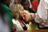 June Steenkamp (L), mother of Reeva Steenkamp, comforts Reeva's cousin Kim Martin during the verdict in the trial of Oscar Pistorius.
