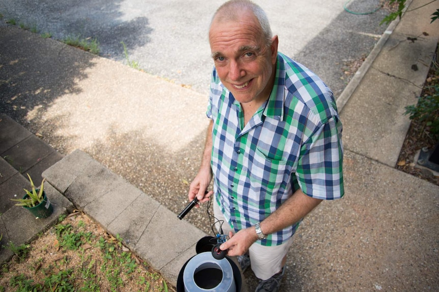 Professor Ritchie stands with the mosquito trap and audio lure that has been developed by researchers at James Cook University.