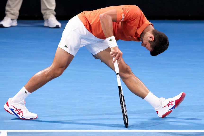 Novak Djokovic grabs his hamstring.