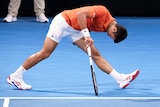 Novak Djokovic grabs his hamstring.