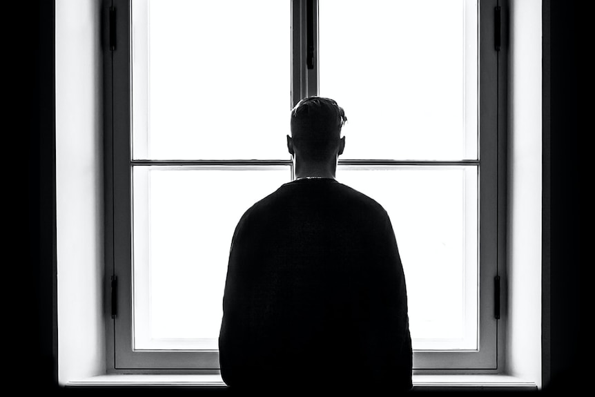 The silhouette of a man against a window