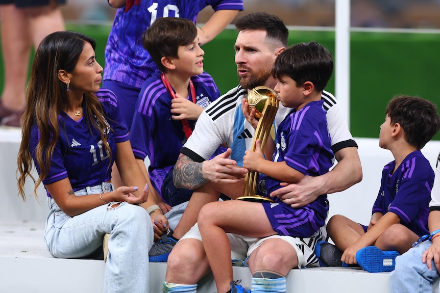 Messi sits with his family on the podium