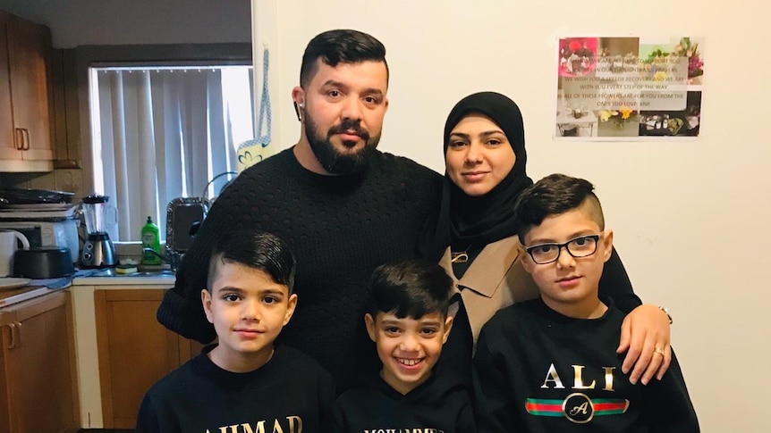 A photograph of a man with a beard, his wife and three boys